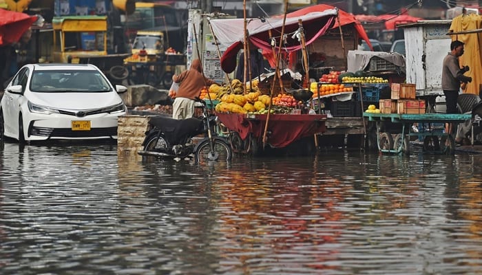 In this image, Fruit carts are half submerged in water. — AFP/File