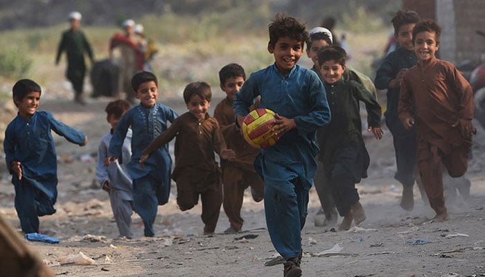 Children play in Afghan Basti area on the outskirts of Lahore on the eve of World Refugee Day. — AFP/File