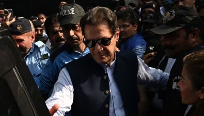 In this image, security personnel escort former prime minister Imran Khan. — AFP/File