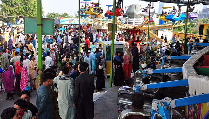 People attend a fun fair ride on the second day of Eid al-Fitr in Karachi on April 12, 2024. — Online