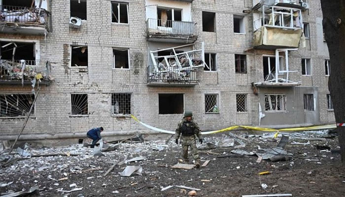 Rescuer works outside a residential building damaged as a result of Russian strikes in Kharkiv on March 27, 2024. — AFP
