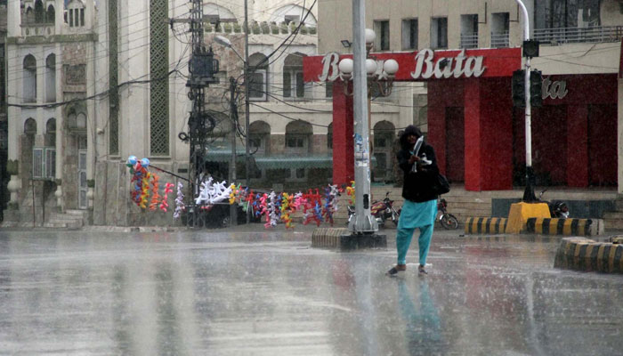Commuters make their way to a road amid rain showers, in Quetta on April 12, 2024. — PPI