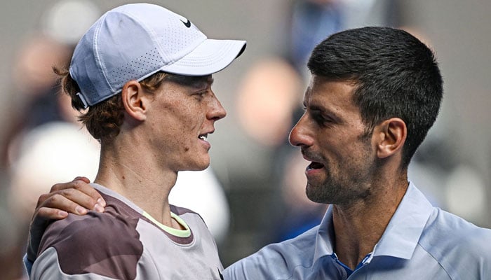 Italys Jannik Sinner (L) greets Serbias Novak Djokovic on January 26, 2024. — AFP