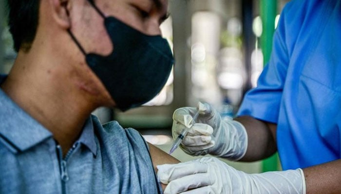 A health worker injects a man with a shot of the vaccine for COVID-19. — AFP/File