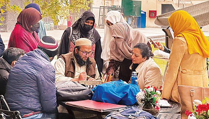 Calligrapher Naveed Maroof teaches calligraphy to his students in Karachi. — Printed in The News/File