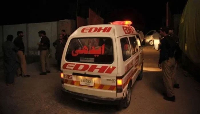 This representational image shows an Edhi ambulance passing by police officials. — AFP/File