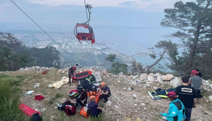 Rescue teams conduct a rescue operation and help injured people after a cable car cabin crashed into a fallen cable pole in the Konyaalti district of Antalya, Turkey on April 12, 2024. — AFP