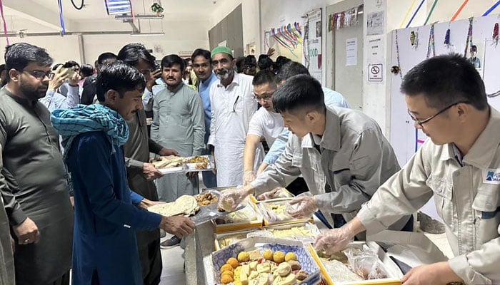 Chinese staff members of the Thar Coal Block-II Coal Electricity Integration project distribute food to Pakistani colleagues to celebrate Eid al-Fitr in the Thar Desert in Pakistans south Sindh province, April 22, 2023. — Xinhua/File