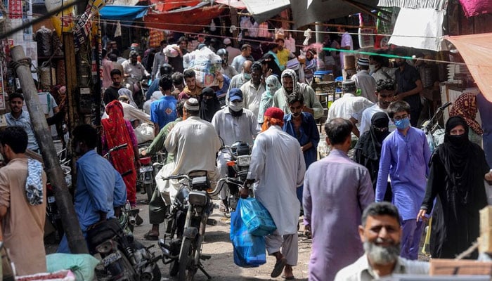 A representational image showing people walking in a wholesale market in Karachi. — AFP/File