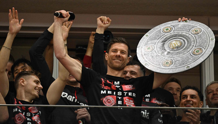 Bayer Leverkusen’s head coach Xabi Alonso celebrates with a mock-up of the Bundesliga trophy with his players. — AFP/File
