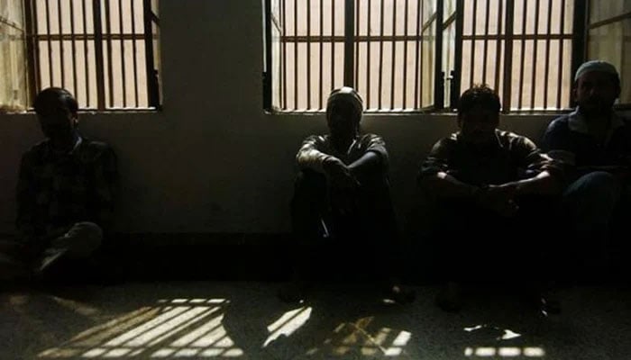 Prisoners sitting inside a dark lockup are seen in this undated image. — AFP/File