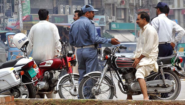 This image shows a traffic police official interacting with a citizen. — Traffic Police Punjab website/File