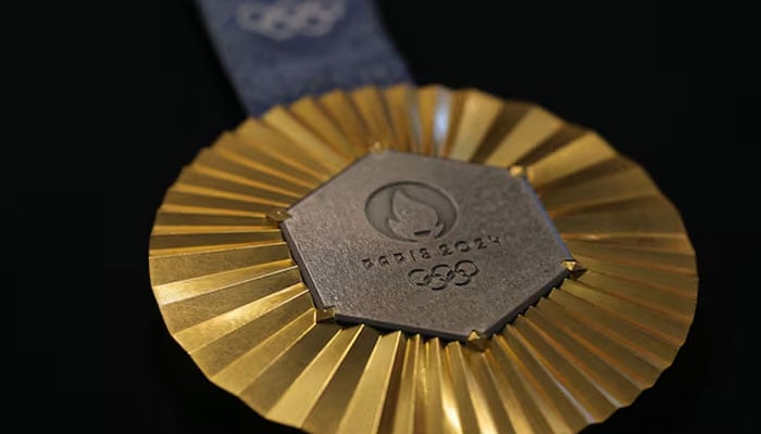 A gold medal featuring iron from the iconic Eiffel Tower. — AFP/File