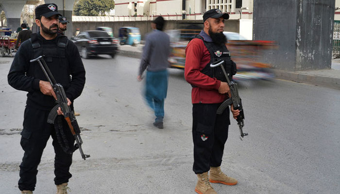 Police personnel can be seen standing guard on a road in KP. — AFP/File