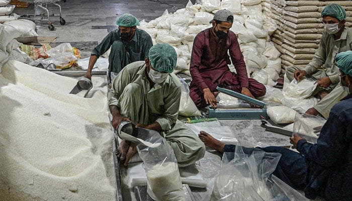 A representational image showing  workers preparing sugar bags  at a warehouse in Islamabad. — AFP/File