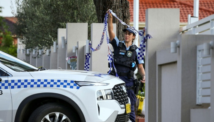 A police officer lifts tape to let a car into the Christ the Good Shepherd Church in western Sydney, scene of a live-streamed stabbing. — AFP/File