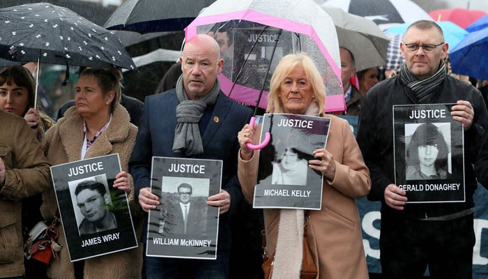 Relatives and supporters of the victims of the 1972 Bloody Sunday killings hold images of those who died. — AFP/File