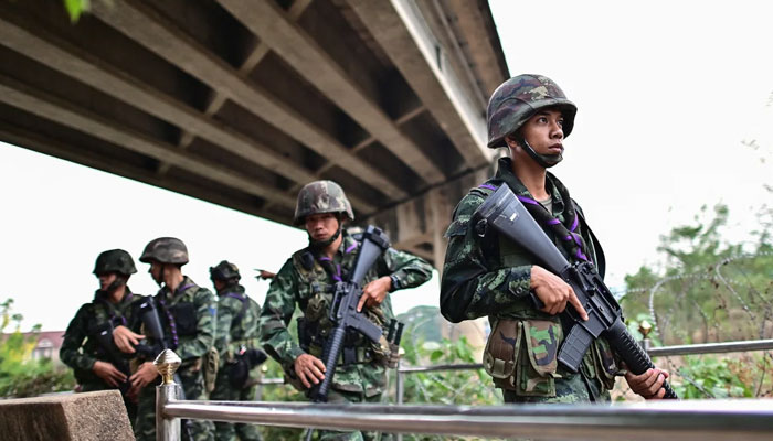 Thai military personnel stand guard overlooking the Moei river on the Thai side, near the Tak border checkpoint with Myanmar, in Thailands Mae Sot district on April 10, 2024. — AFP