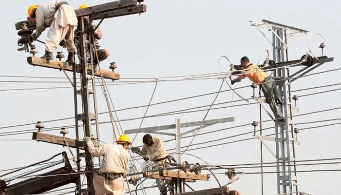 Pakistani technicians work on high-voltage power lines. — AFP/File