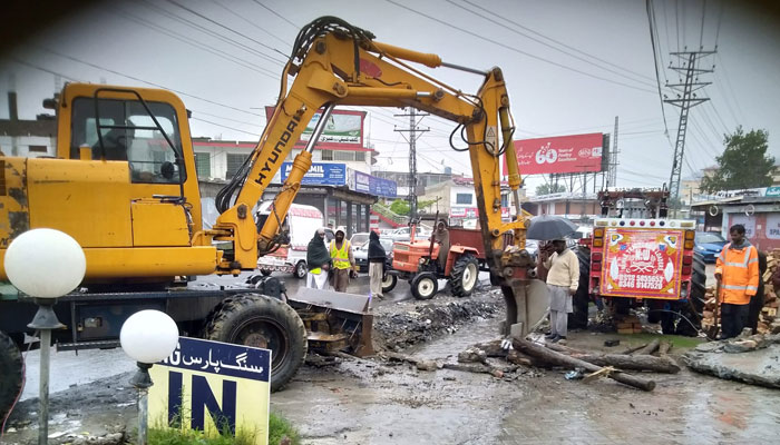 In this image, Tehsil Municipal Administration Mansehra workers clear the choked sewerage lines along with heavy Machinery during a cleaning operation on April 20, 2024. — Facebook/Tehsil Municipal Administration Mansehra
