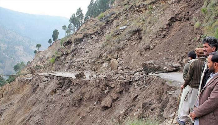 This picture shows people standing near landslides. — Geo Tv/File
