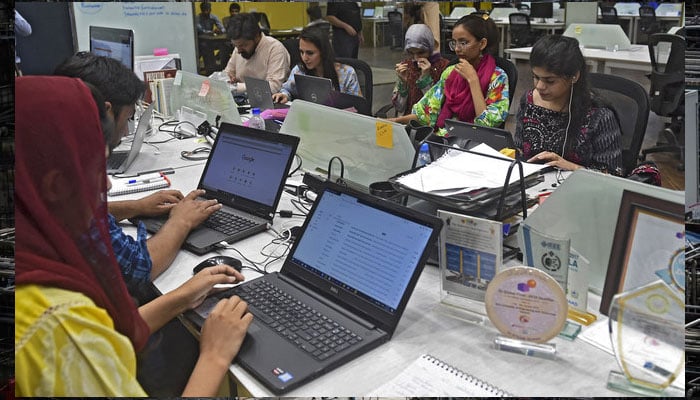 People work at their stations at the National Incubation Centre (NIC) in Lahore, Pakistan. — AFP/File