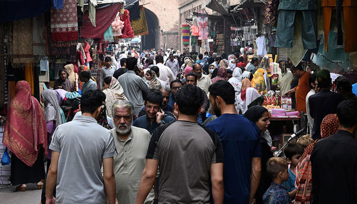 In this picture taken on April 16, 2023, people throng a market area during shopping in Lahore. — AFP