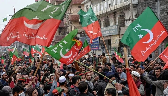 Supporters and activists of the Pakistan Tehreek-e-Insaf (PTI) hold flags at a rally. — AFP/File