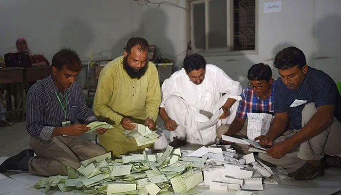 Election officials count ballot papers after polls close at a polling station. — AFP/File