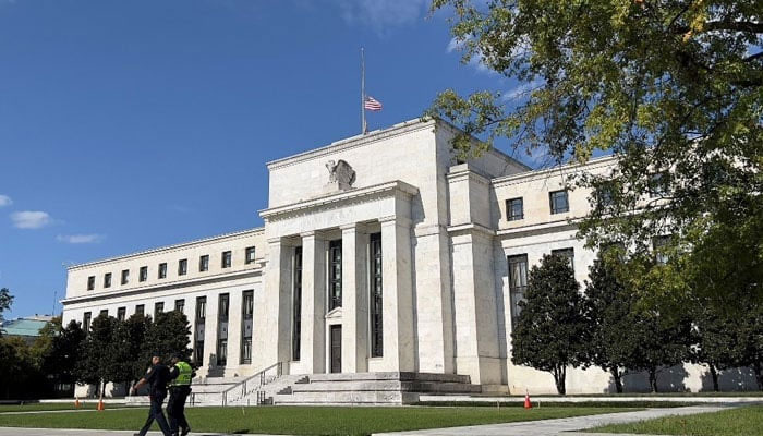 Security personnel walk past the US Federal Reserve building in Washington, DC on Oct 22, 2021. — AFP