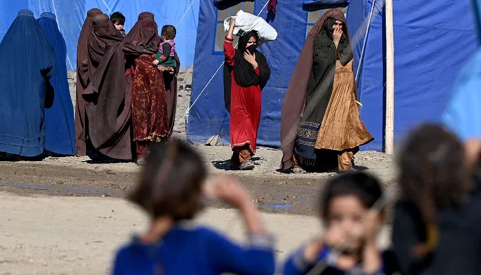 Afghan refugees walk through a makeshift camp upon their arrival from Pakistan, near the Torkham border in Nangarhar. — AFP/File