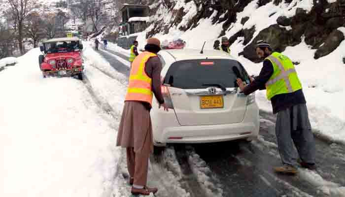 Workers of Kaghan Development Authority (KDA) rescuing a vehicle during heavy snowfall. — PPI/File