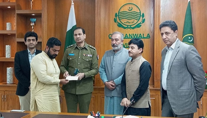 In this image, Regional Police Officer (RPO) Tayab Hafeez Cheema distributes a cheque to a family member of  a Noshki terrorism victim on April 23, 2024. — Facebook/Commissioner Gujranwala, Division, Gujranwala
