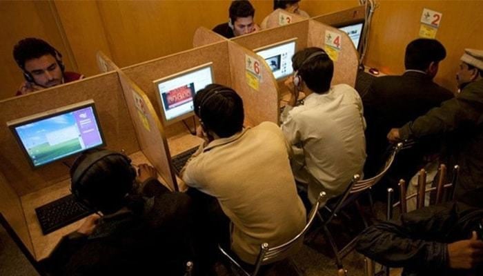 A representational image showing people surfing the internet at an internet cafe. — AFP/File