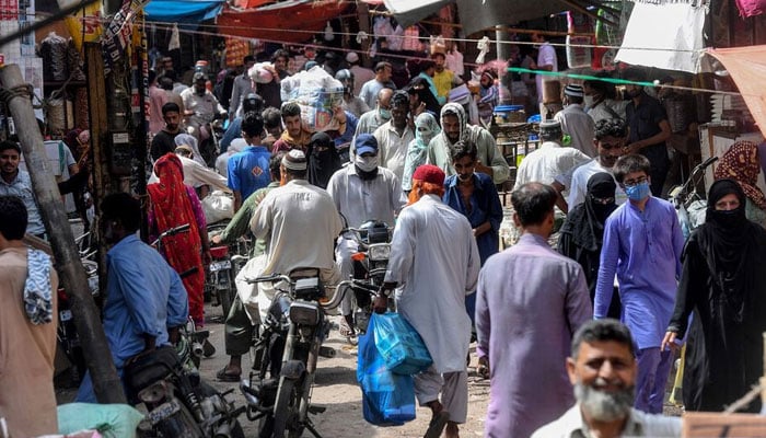 A representational image showing residents walking at a wholesale market in Karachi. — AFP/File
