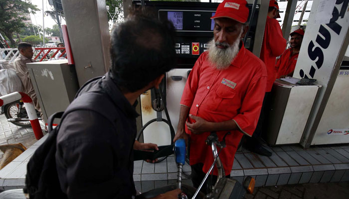 A fuel station worker filling petrol in vehicle at a fuel station in Karachi on Tuesday, April 16, 2024