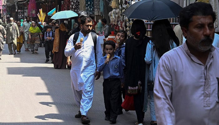 People walk along a market in Lahore on May 17, 2023. — AFP/File