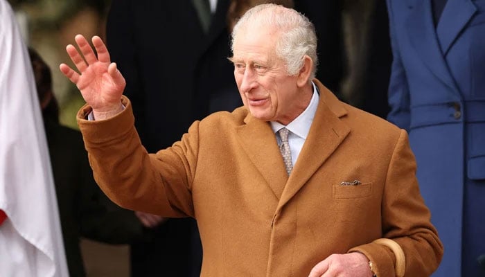 Britains King Charles III waves to well-wishers at St Mary Magdalene Church on the Sandringham Estate in eastern England on December 25, 2023. — AFP