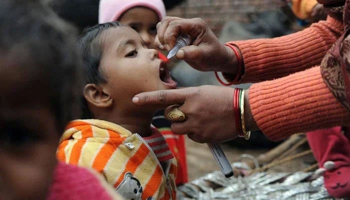 A child is being administered polio drops by a health worker. — AFP/File