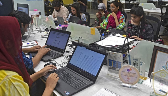 People work at their stations at the National Incubation Centre (NIC) in Lahore. — AFP/File