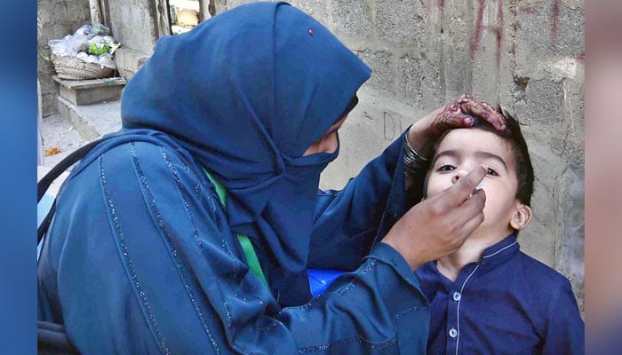 A lady health worker administering polio drops to a child on April 29, 2024. — APP