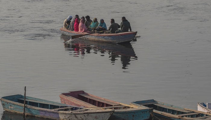 Visitors take a leisure ride on a boat in Ravi river in Lahore. — AFP/File