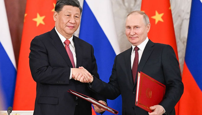 Chinese President Xi Jinping and Russian President Vladimir Putin shake hands in Moscow in March 2023. — AFP