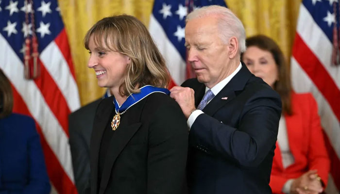 US President Joe Biden presents the Presidential Medal of Freedom to US swimmer Katie Ledecky (L) in the East Room of the White House. — AFP File