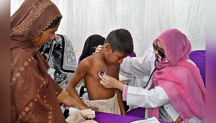 In this image, a lady Doctor examines a child in a medical camp. — APP/File