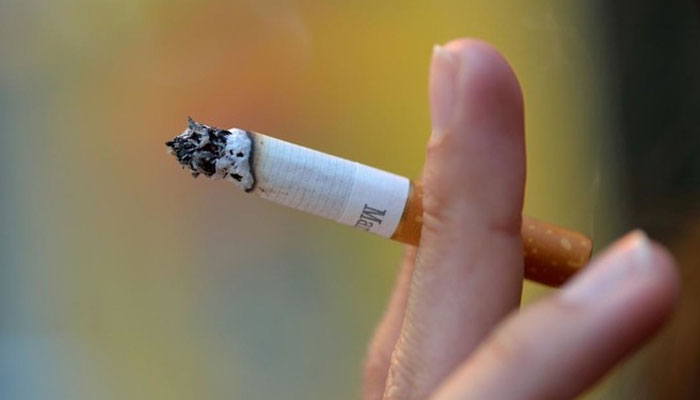 A representational image shows a person holding a cigarette between the fingers. — AFP/File