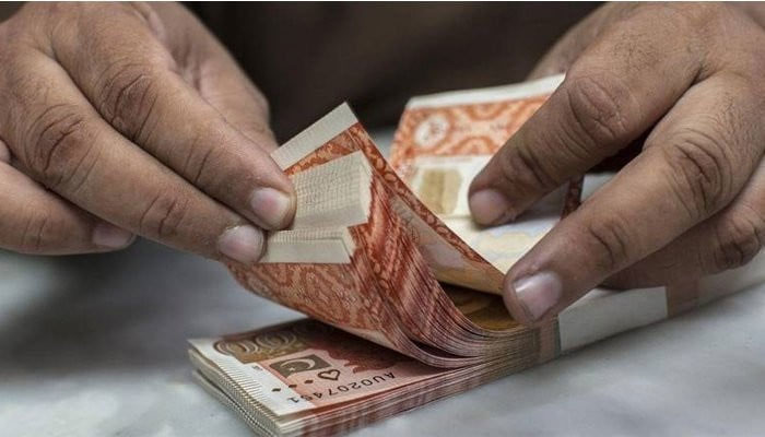 A man counting RS5,000 currency notes. — AFP/File