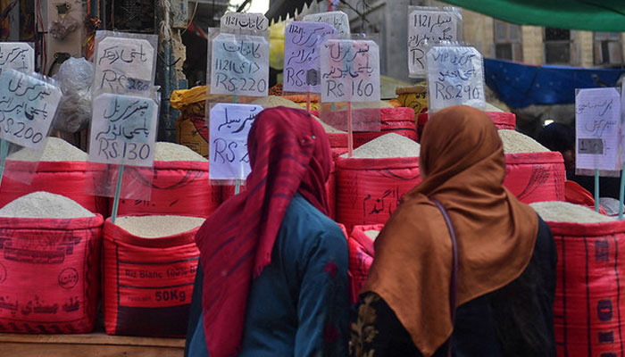 In this picture taken on January 10, 2023, women check rice prices at a main wholesale market in Karachi. — AFP/File