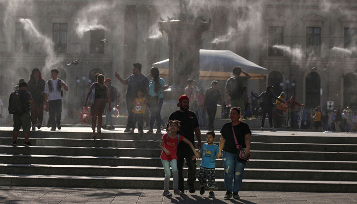 People walk as water is sprayed by a system to alleviate the high temperatures caused by a heat wave, at the Gerardo Barrios square, in San Salvador, El Salvador, March 27, 2024. — Reuters