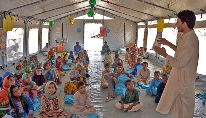 Children attend a class at a makeshift school at Dera Allah Yar in Jaffarabad on September 21, 2022. — AFP